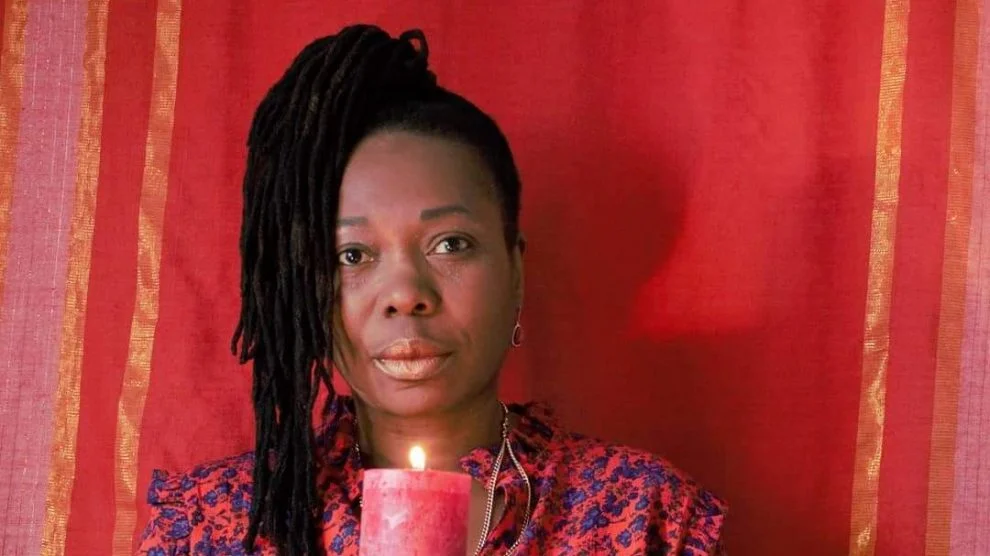Mulher negra segurando uma vela vermelha